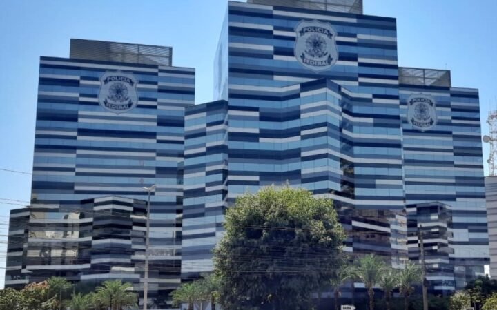 Torres de vidro azul com o brasão da Polícia Federal na fachada, em Brasília