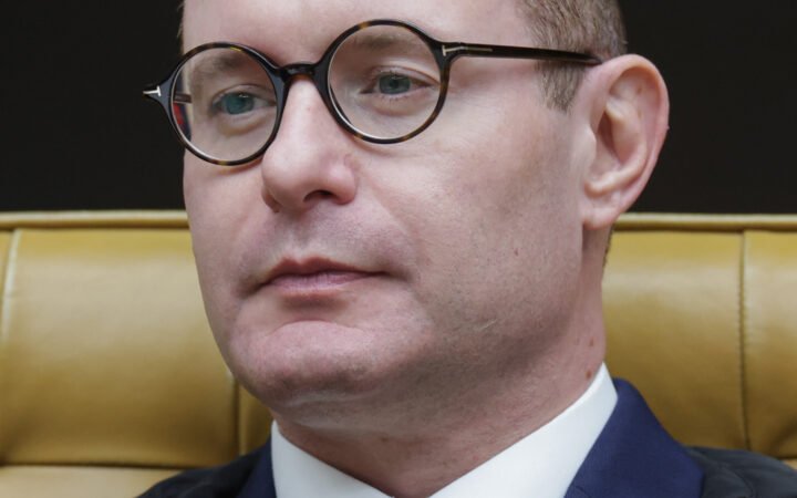O ministro Cristiano Zanin, de óculos redondos e terno azul, sentado em sessão plenária do Supremo Tribunal Federal