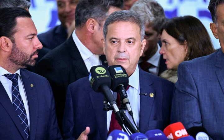 Senador Rogério Marinho fala diante de microfones de emissoras, cercado por parlamentares, no Senado