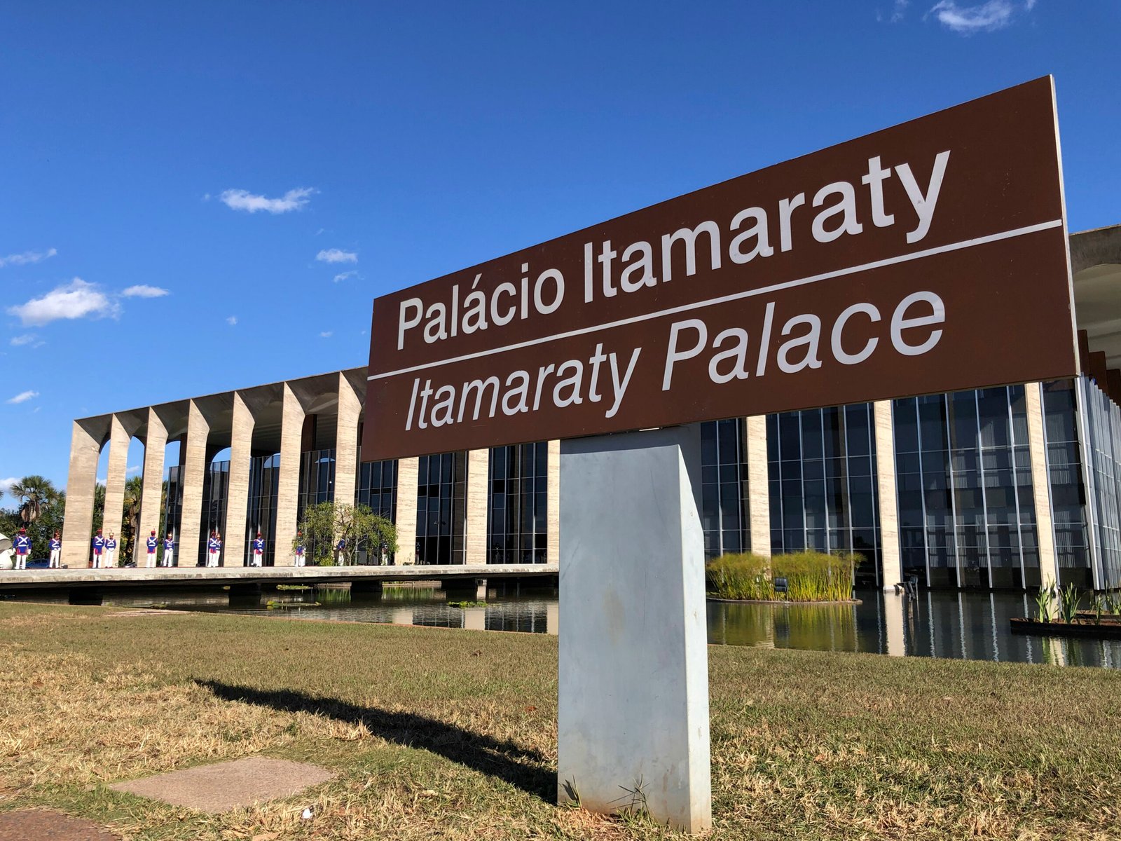 Fachada do Palácio Itamaraty, em Brasília, com placa de identificação em primeiro plano e guardas ao fundo