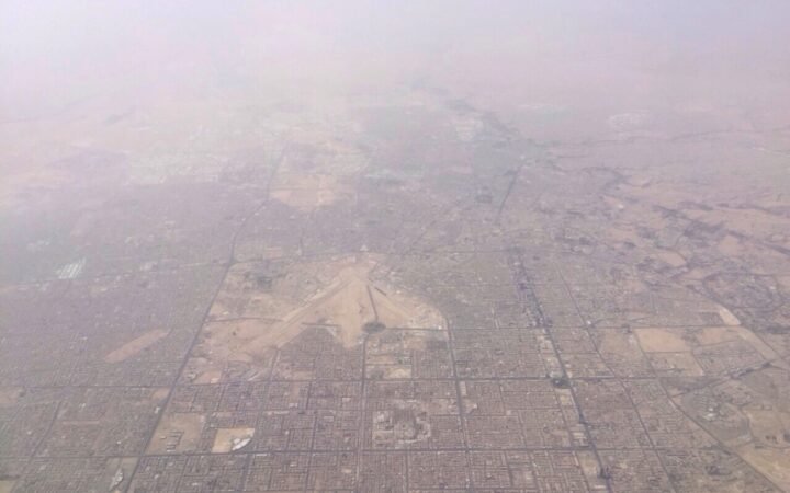Vista aérea de Riad, na Arábia Saudita, com o Aeroporto Internacional Rei Khalid ao centro, sob neblina