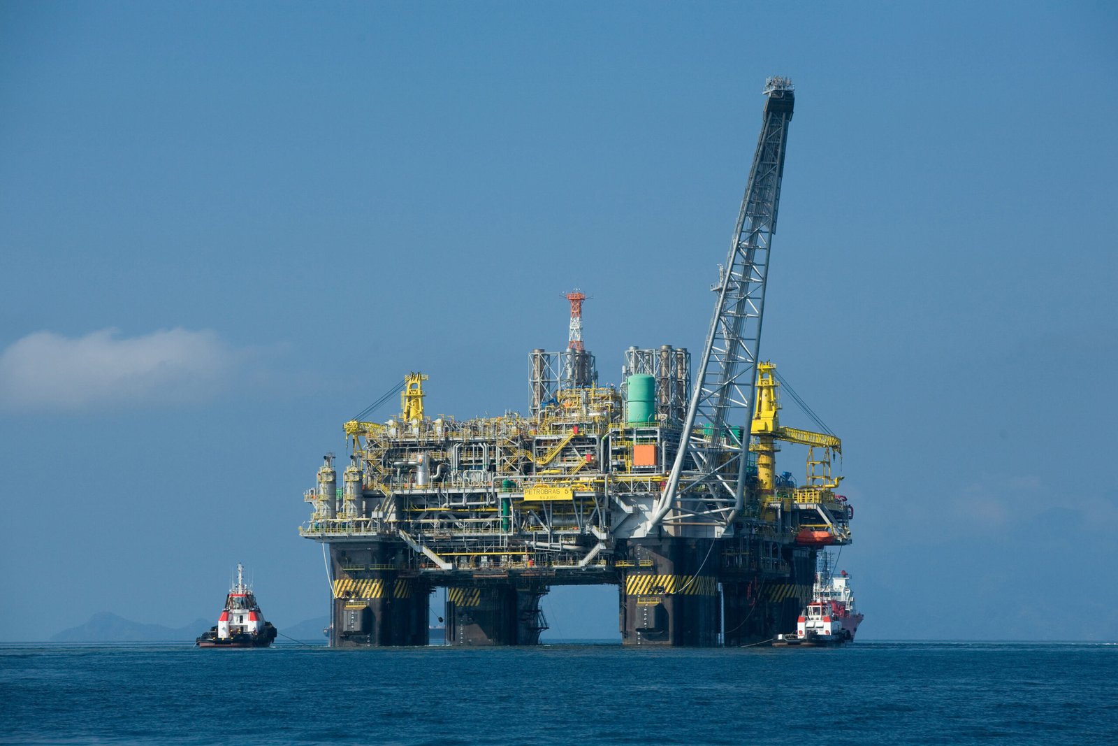 Plataforma semissubmersível de petróleo P-51 no mar, com dois rebocadores