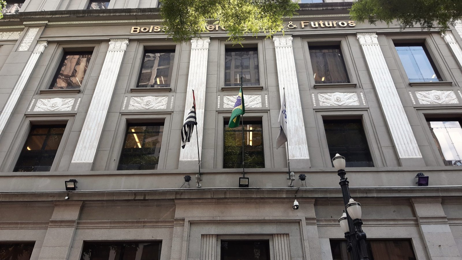 Fachada do edifício da antiga Bolsa de Mercadorias & Futuros, na Praça Antônio Prado, centro de São Paulo, com bandeiras do Brasil e de São Paulo