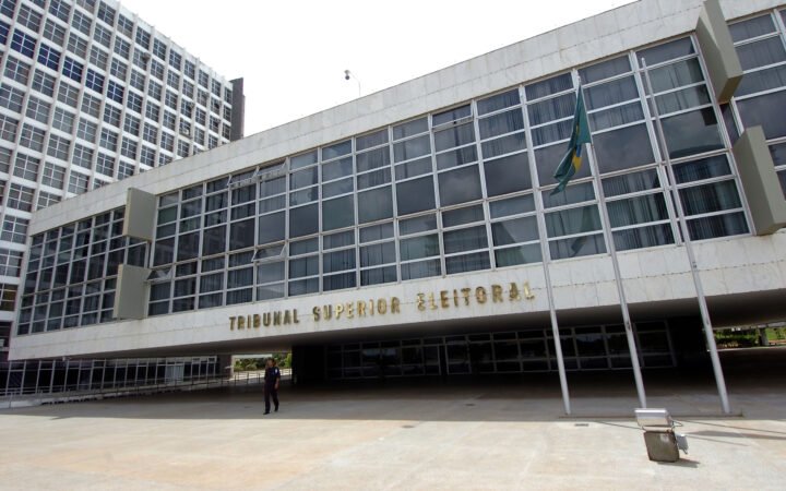 Fachada do edifício-sede do Tribunal Superior Eleitoral, em Brasília, com as letras douradas do nome do tribunal e a bandeira do Brasil
