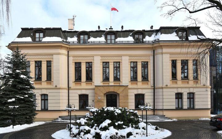 Fachada do prédio do Tribunal Constitucional da Polônia, em Varsóvia, com neve e a bandeira polonesa no alto