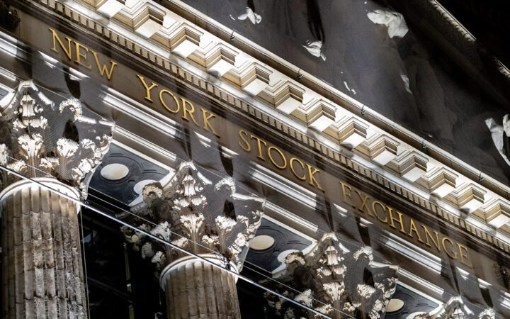 Fachada de colunas da Bolsa de Nova York, com o nome New York Stock Exchange em letras douradas