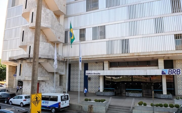 Fachada do edifício-sede do Banco de Brasília (BRB), com o letreiro do banco e bandeiras na entrada.