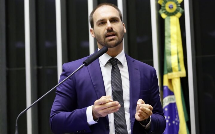 Eduardo Bolsonaro, de terno azul e gravata, fala ao microfone no plenário da Câmara dos Deputados