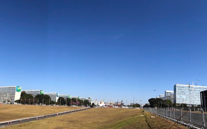 Vista da Esplanada dos Ministérios, em Brasília, com os prédios dos ministérios em fila sob céu azul