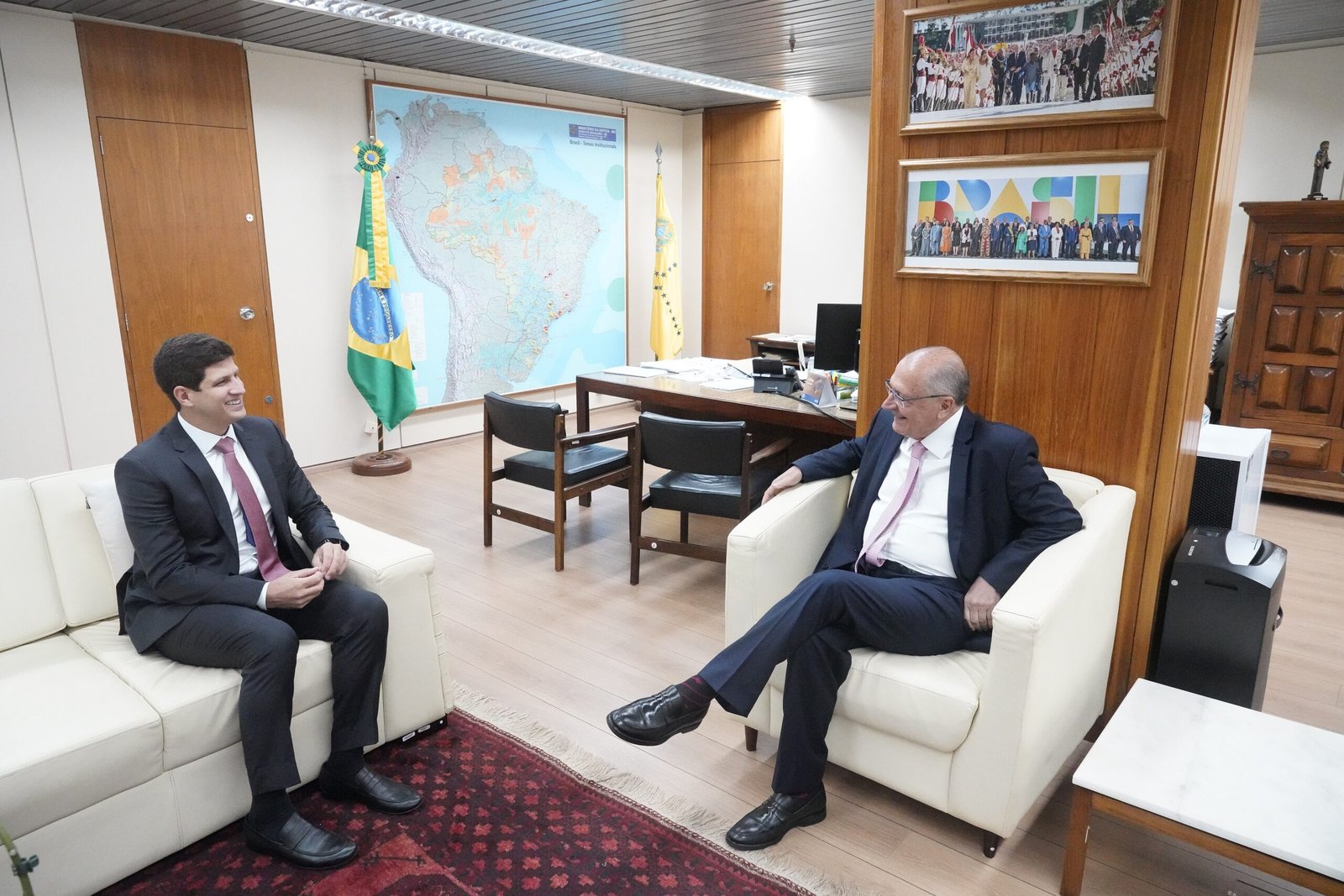 João Campos, então prefeito do Recife, e o vice-presidente Geraldo Alckmin conversam sentados em sala do ministério em Brasília