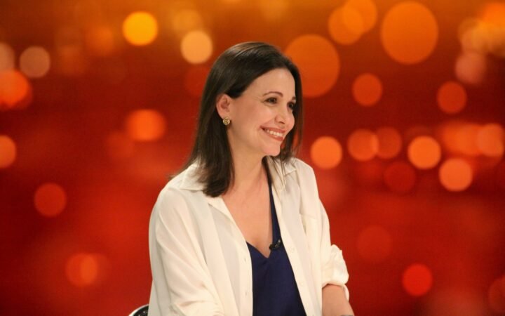 A líder da oposição venezuelana María Corina Machado sorri durante entrevista em estúdio