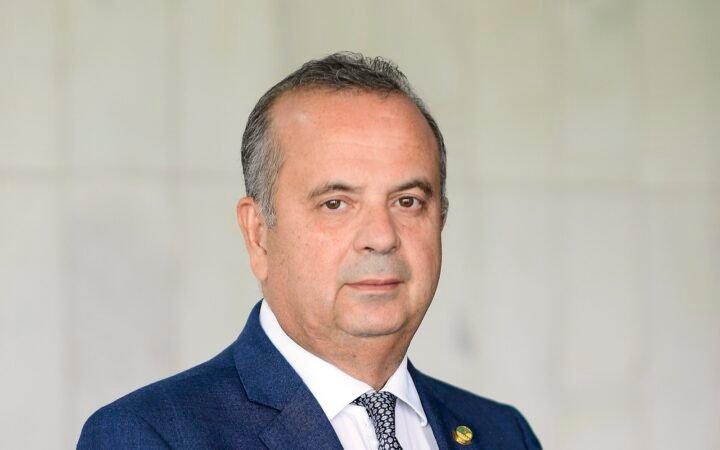 Retrato do senador Rogério Marinho (PL-RN), de terno azul e gravata estampada, diante de parede clara