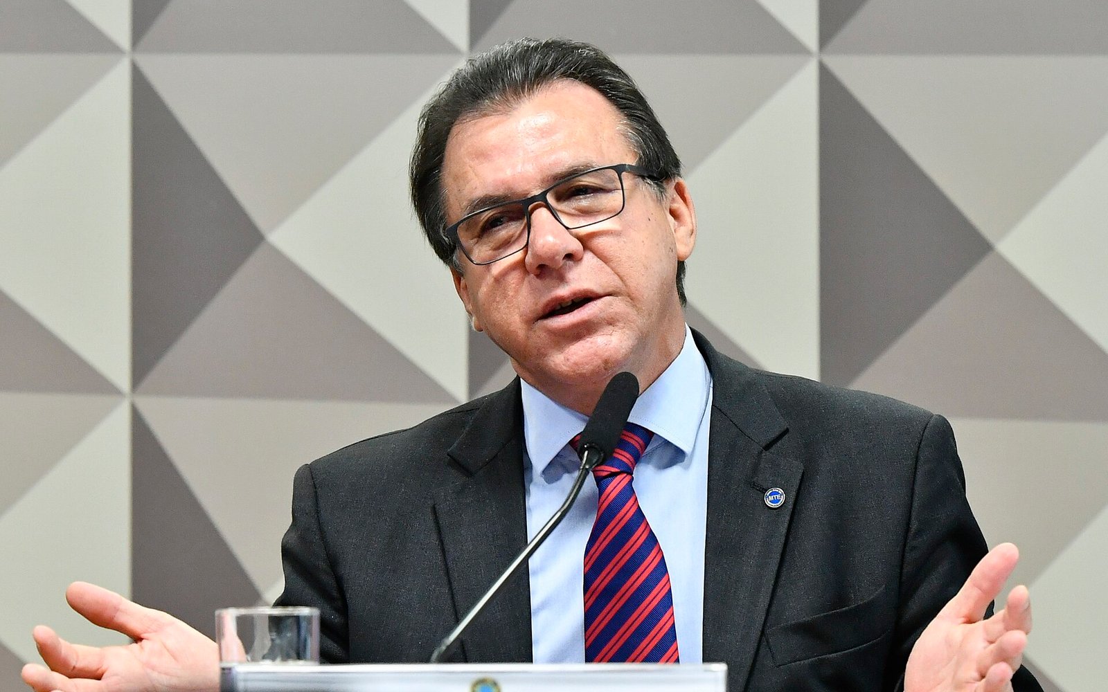 Luiz Marinho, de óculos e terno escuro, fala ao microfone em audiência pública na Comissão de Direitos Humanos do Senado.
