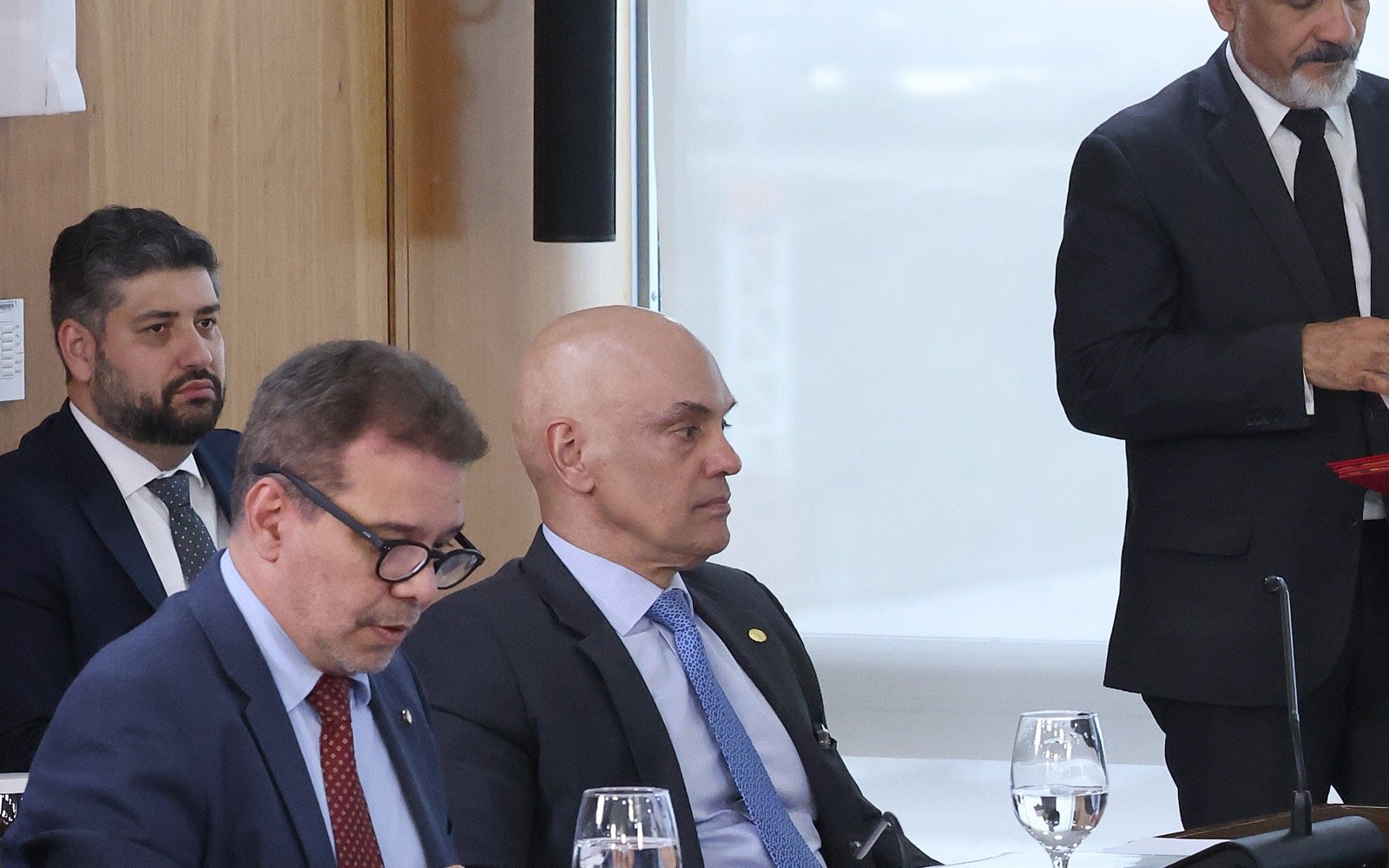O ministro Alexandre de Moraes, de terno e gravata azul, sentado a uma mesa em reunião em Brasília