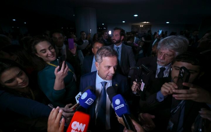 O senador Rogerio Marinho fala a jornalistas, cercado por microfones, no Senado