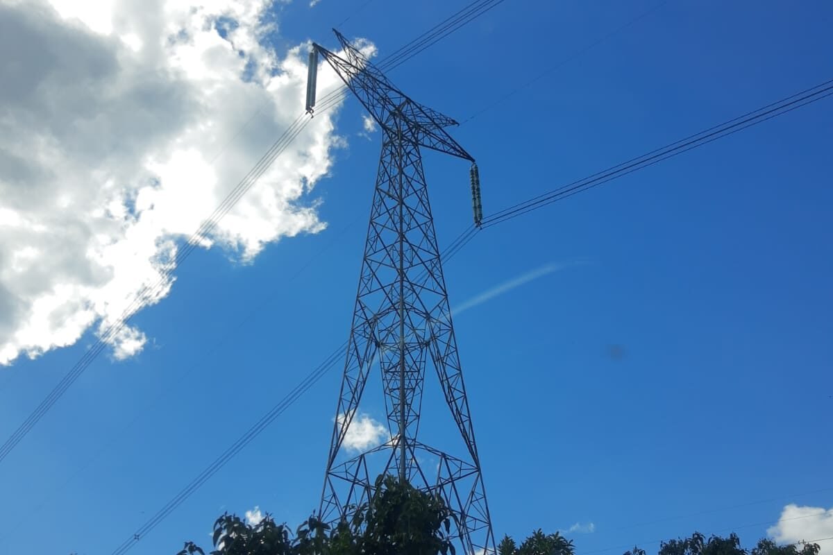 Torre metálica de linha de transmissão de energia elétrica, com cabos no céu azul, em Telêmaco Borba, Paraná