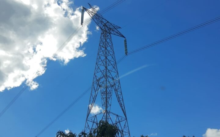 Torre metálica de linha de transmissão de energia elétrica, com cabos no céu azul, em Telêmaco Borba, Paraná