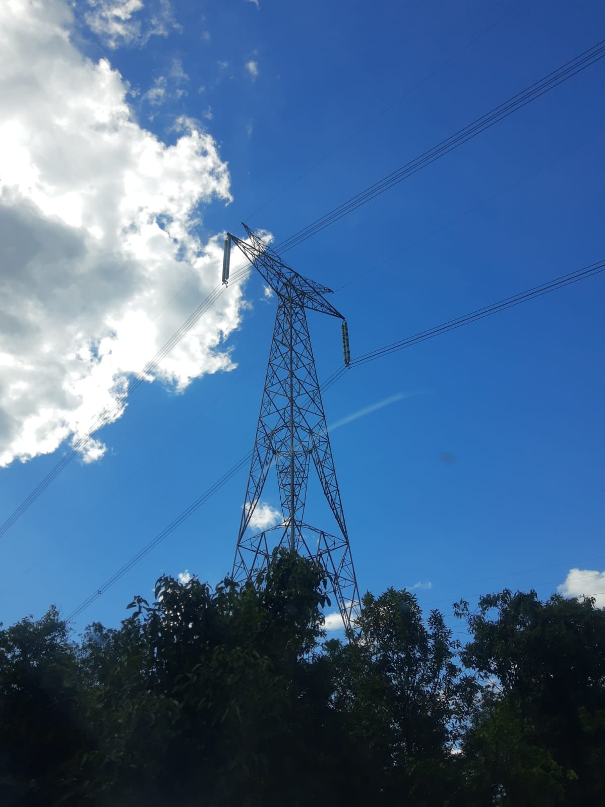 Torre metálica de linha de transmissão de energia elétrica, com cabos no céu azul, em Telêmaco Borba, Paraná