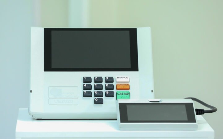 Urna eletrônica brasileira modelo UE2020, com tela, teclado numérico e terminal do mesário.
